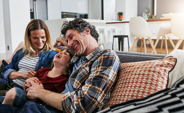 Family sitting on a sofa laughing
