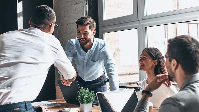 Two men shaking hands during an office meeting