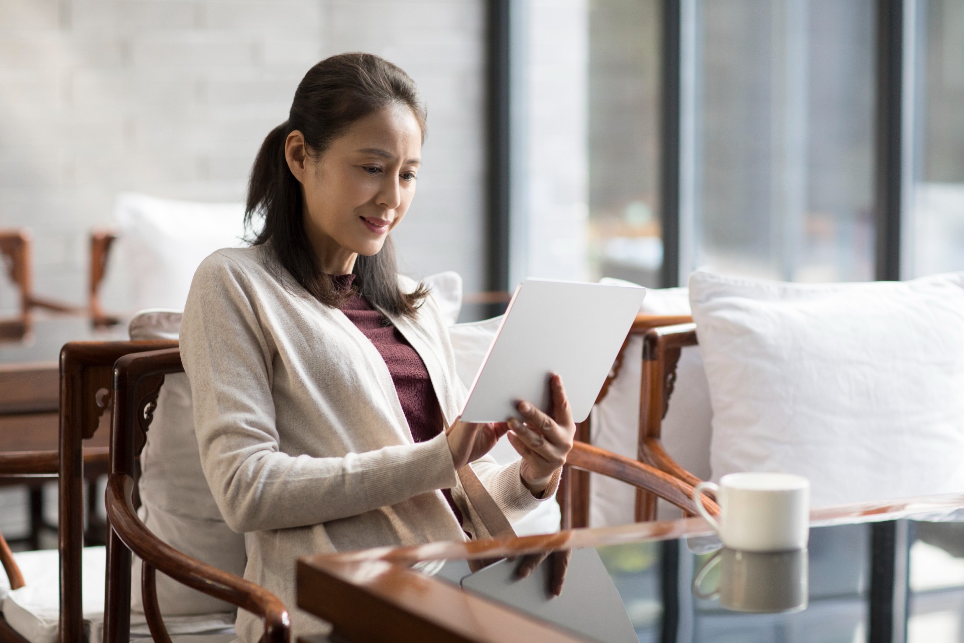 Woman sitting at a table reading a book