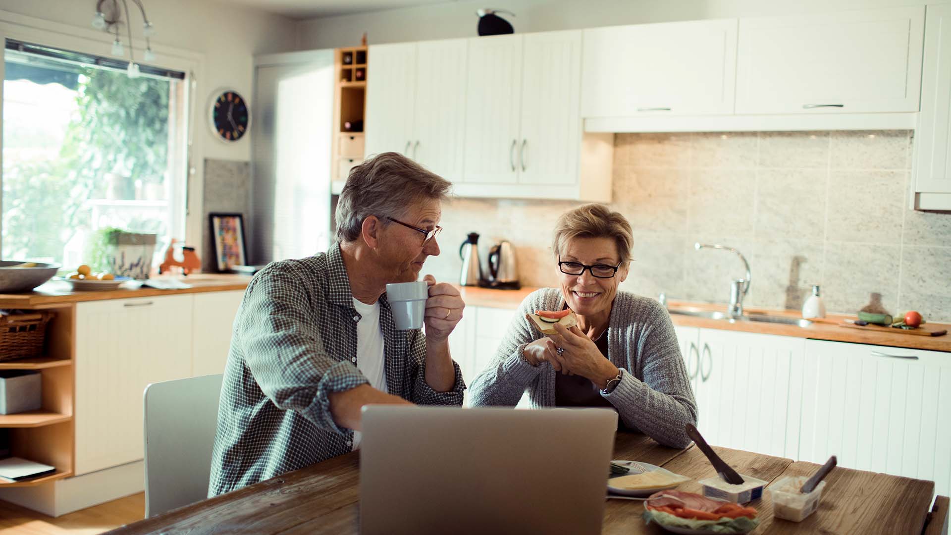 Couple sitting at a table looking at a computer
